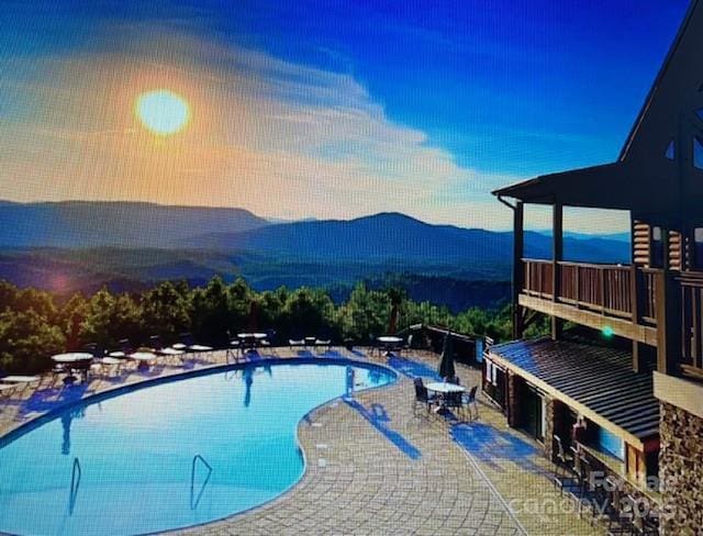 community pool with a patio area and a mountain view