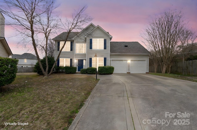 view of front of house featuring concrete driveway, fence, and an attached garage