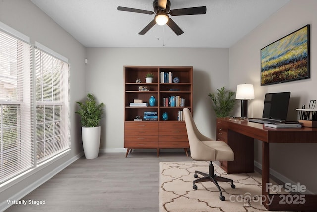 office area featuring baseboards, a ceiling fan, and wood finished floors