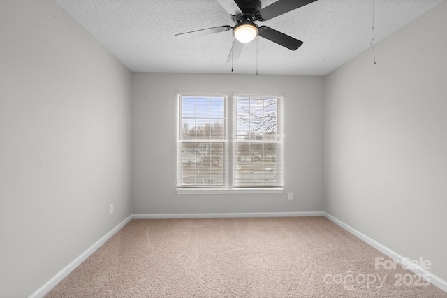 unfurnished room with a textured ceiling, carpet, and baseboards