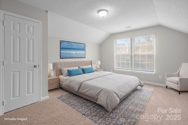 carpeted bedroom featuring lofted ceiling, a textured ceiling, visible vents, and baseboards