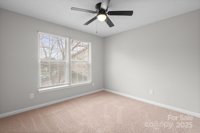 unfurnished room with a textured ceiling, carpet flooring, and baseboards