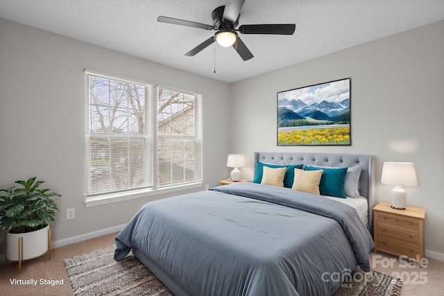 carpeted bedroom featuring ceiling fan, a textured ceiling, and baseboards