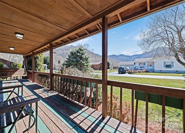 deck featuring a mountain view and a lawn