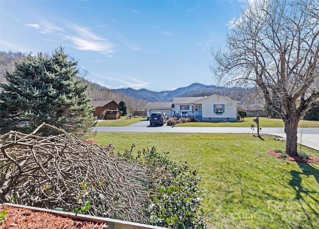 view of yard featuring concrete driveway and a mountain view