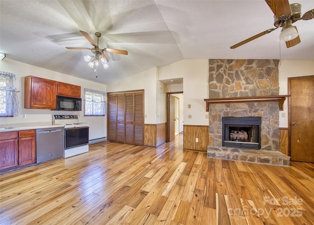 kitchen with black microwave, wainscoting, white range with electric stovetop, dishwasher, and light wood finished floors