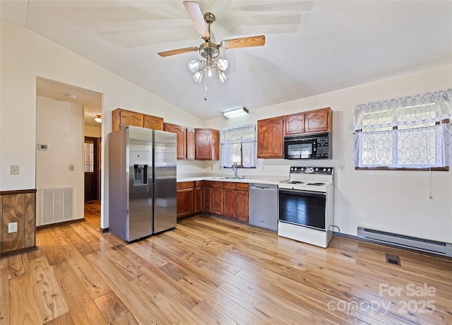 kitchen featuring light countertops, visible vents, light wood-style flooring, baseboard heating, and appliances with stainless steel finishes