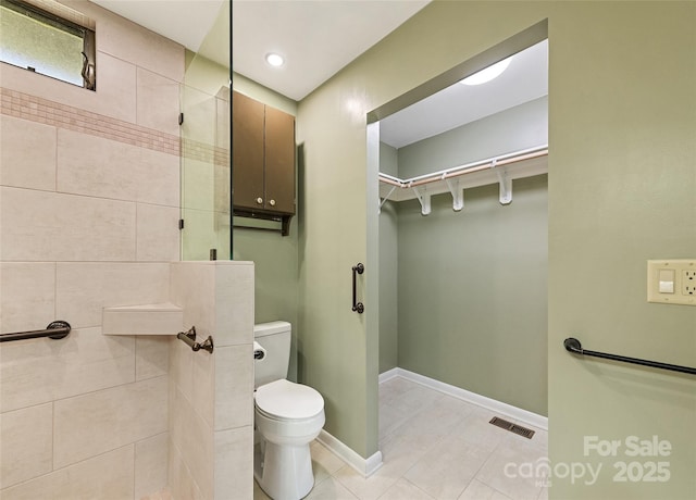 full bathroom featuring visible vents, toilet, tile patterned flooring, tiled shower, and baseboards