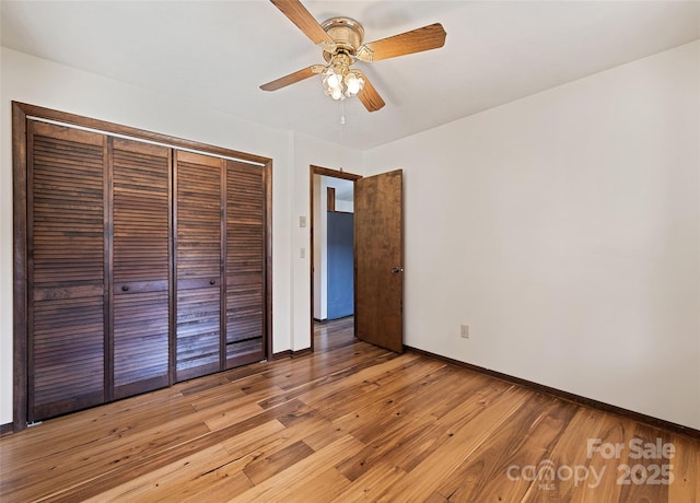 unfurnished bedroom featuring light wood-type flooring, a ceiling fan, baseboards, and a closet