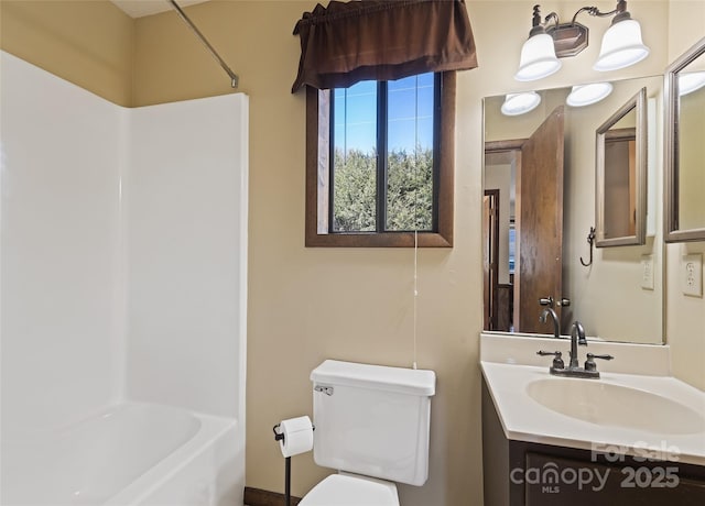 bathroom with tub / shower combination, vanity, and toilet