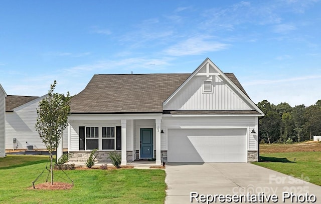 view of front of property featuring a garage, stone siding, driveway, a front lawn, and board and batten siding