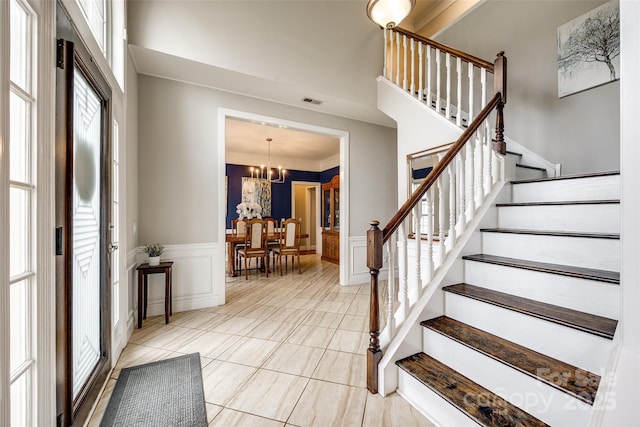 foyer entrance featuring a wainscoted wall, stairway, and a decorative wall