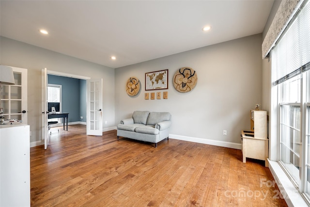 sitting room with light wood-style floors, baseboards, and french doors