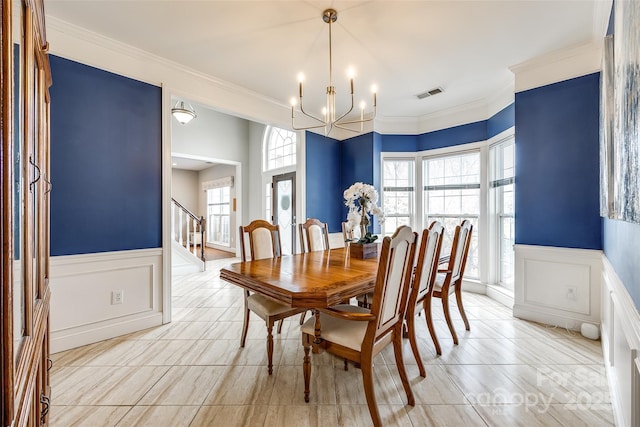 dining room featuring a chandelier, visible vents, stairs, ornamental molding, and wainscoting