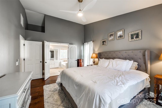 bedroom featuring high vaulted ceiling, dark wood-style flooring, connected bathroom, and ceiling fan