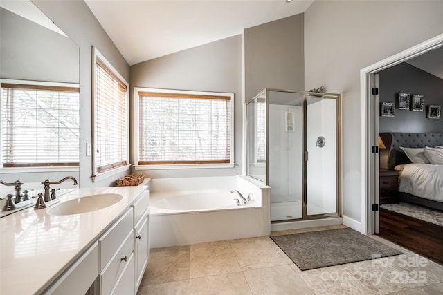 ensuite bathroom featuring ensuite bathroom, tile patterned flooring, vaulted ceiling, a shower stall, and a bath