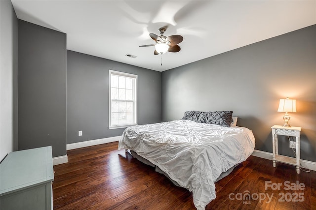 bedroom with a ceiling fan, wood finished floors, visible vents, and baseboards