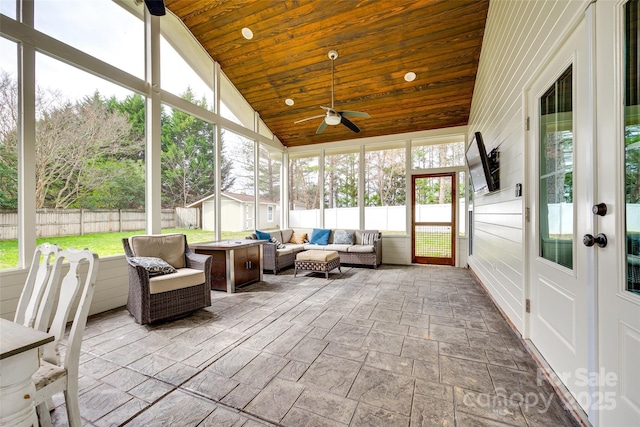 sunroom / solarium with lofted ceiling, wood ceiling, and a ceiling fan