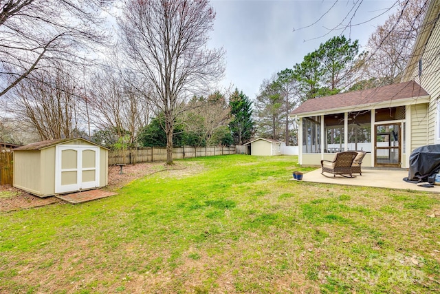 view of yard featuring a storage unit, a sunroom, a patio area, a fenced backyard, and an outdoor structure