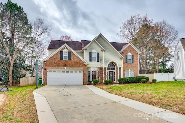 traditional home with driveway, a front yard, fence, and brick siding