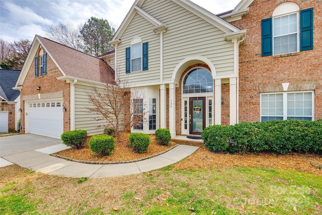 view of front of house featuring concrete driveway and brick siding