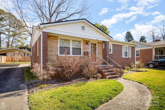 bungalow-style home featuring brick siding, fence, driveway, and a front lawn