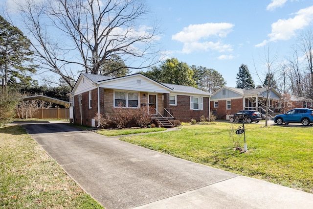 single story home featuring driveway, brick siding, a front lawn, and a detached carport