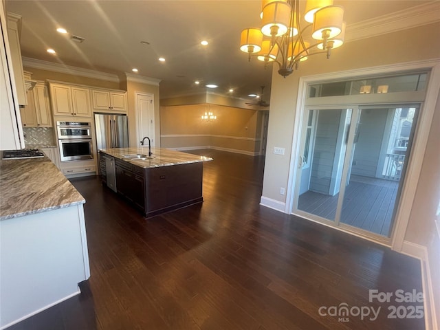 kitchen featuring stainless steel appliances, dark wood finished floors, a notable chandelier, and a sink