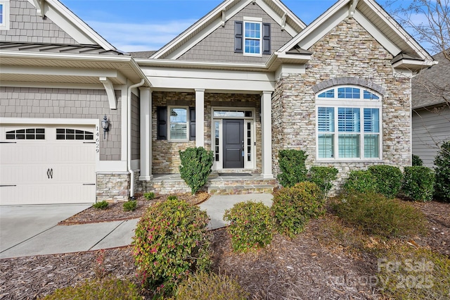 view of front of house featuring a garage, stone siding, covered porch, and a standing seam roof