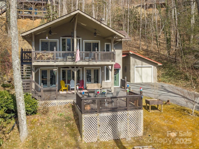 view of front of property featuring a deck, a ceiling fan, and an outdoor structure