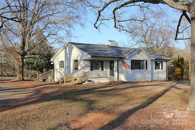 view of front of home featuring a chimney and a front yard