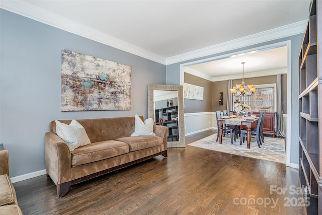 living area featuring baseboards, a chandelier, dark wood-type flooring, and ornamental molding