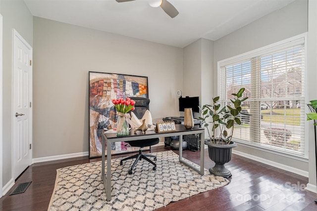 office space featuring dark wood-type flooring, visible vents, baseboards, and a ceiling fan