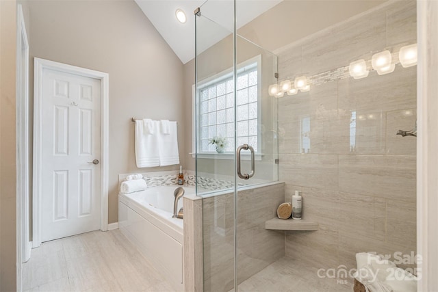 full bathroom with vaulted ceiling, a shower stall, and a bath