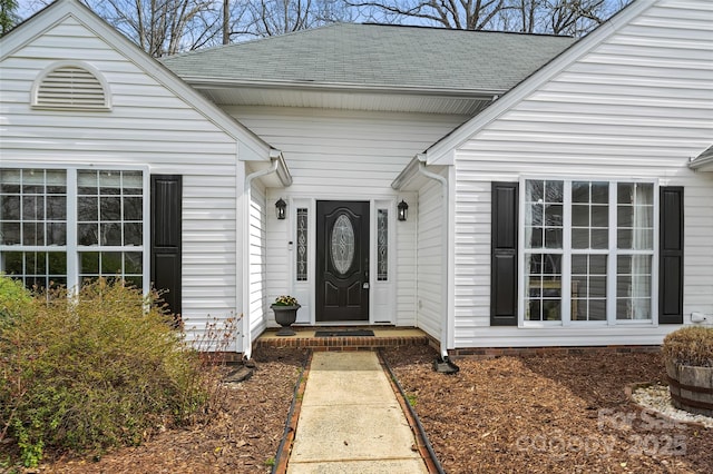 entrance to property with a shingled roof