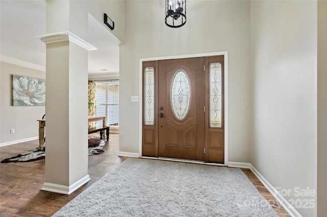 foyer with ornate columns, baseboards, and wood finished floors