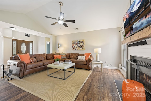 living area featuring a large fireplace, baseboards, visible vents, wood finished floors, and high vaulted ceiling