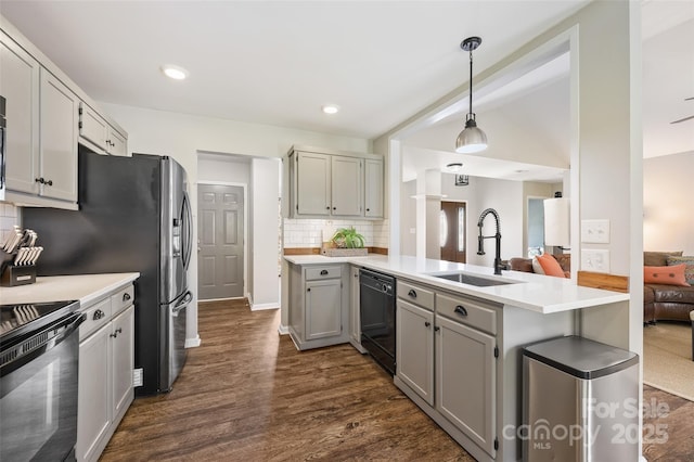 kitchen featuring decorative backsplash, dark wood-style flooring, gray cabinetry, black appliances, and a sink