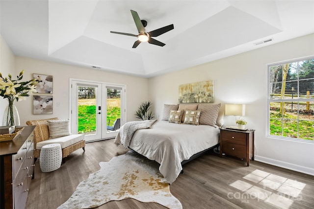 bedroom with access to exterior, visible vents, and a tray ceiling