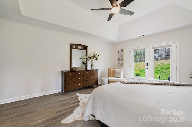 bedroom featuring wood finished floors, baseboards, access to exterior, french doors, and a tray ceiling