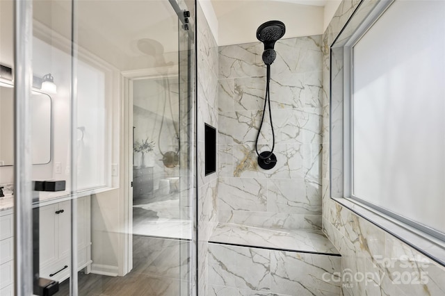 full bathroom with a marble finish shower and vanity