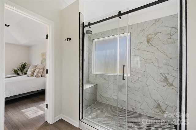 full bath featuring a marble finish shower, baseboards, wood finished floors, and ensuite bathroom