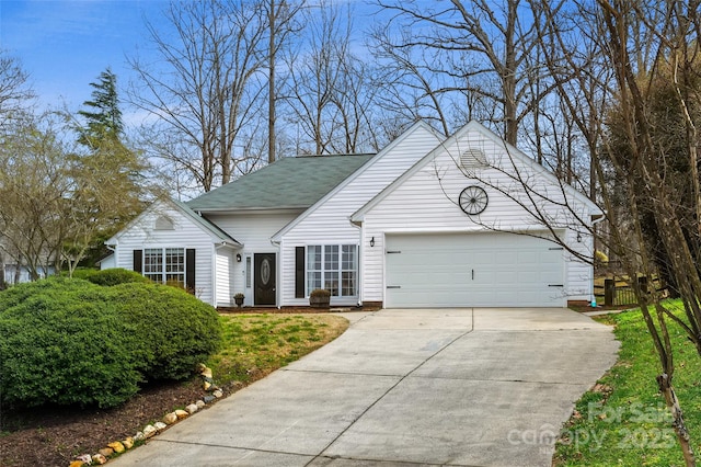 view of front of property featuring a garage, fence, and concrete driveway