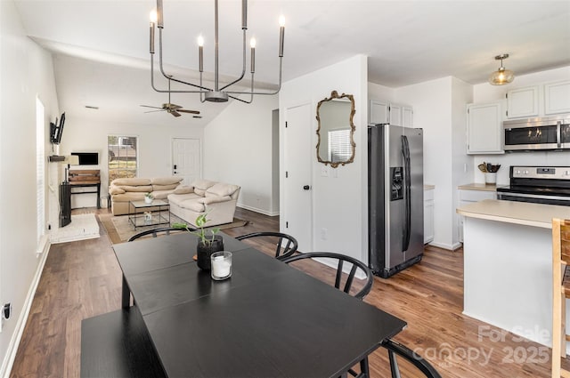 dining room featuring dark wood-type flooring, ceiling fan, and baseboards