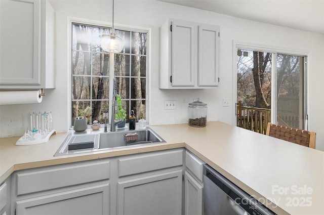 kitchen with light countertops, dishwasher, and decorative light fixtures