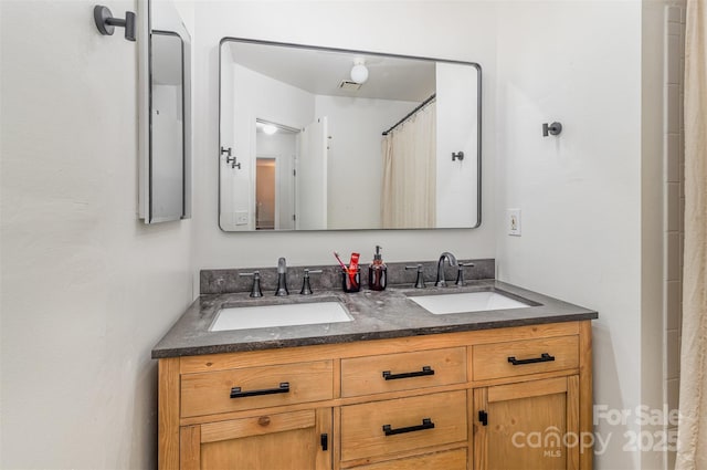 full bath featuring visible vents, a sink, and double vanity