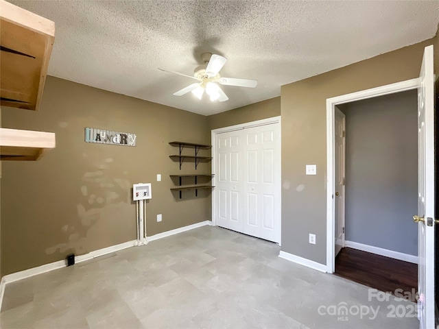 clothes washing area with washer hookup, a ceiling fan, a textured ceiling, laundry area, and baseboards