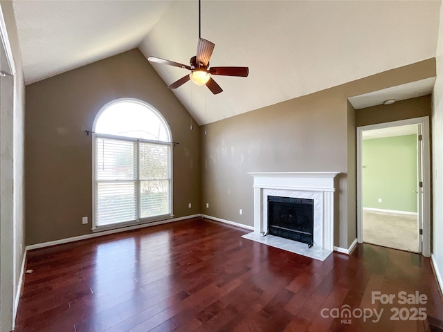 unfurnished living room featuring baseboards, ceiling fan, dark wood-type flooring, high vaulted ceiling, and a high end fireplace