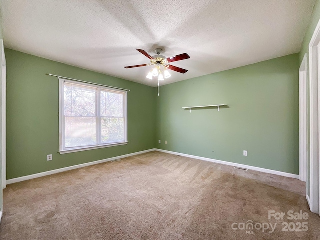 unfurnished room with visible vents, baseboards, a ceiling fan, a textured ceiling, and carpet floors