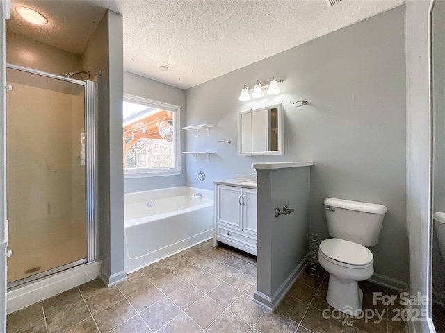 bathroom featuring a garden tub, toilet, a stall shower, vanity, and a textured ceiling